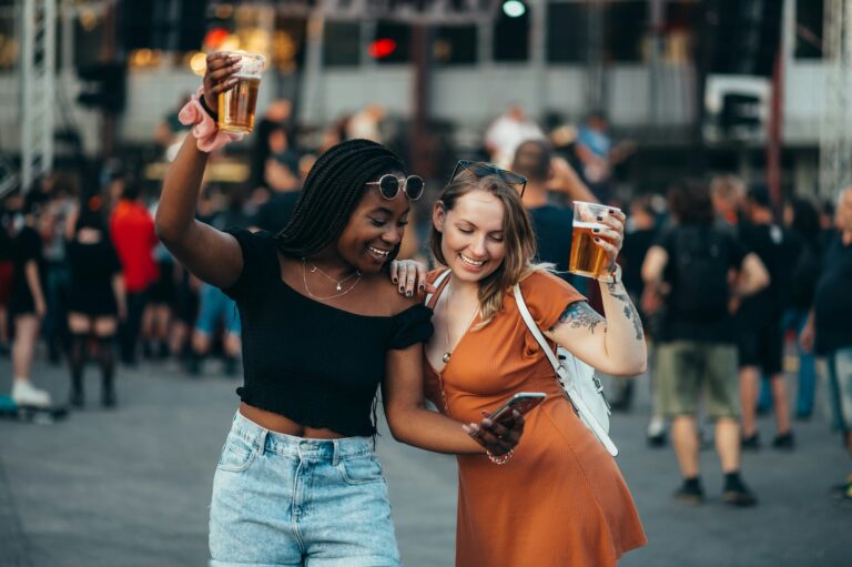 friends-using-smartphone-and-drinking-beer-on-a-music-festival