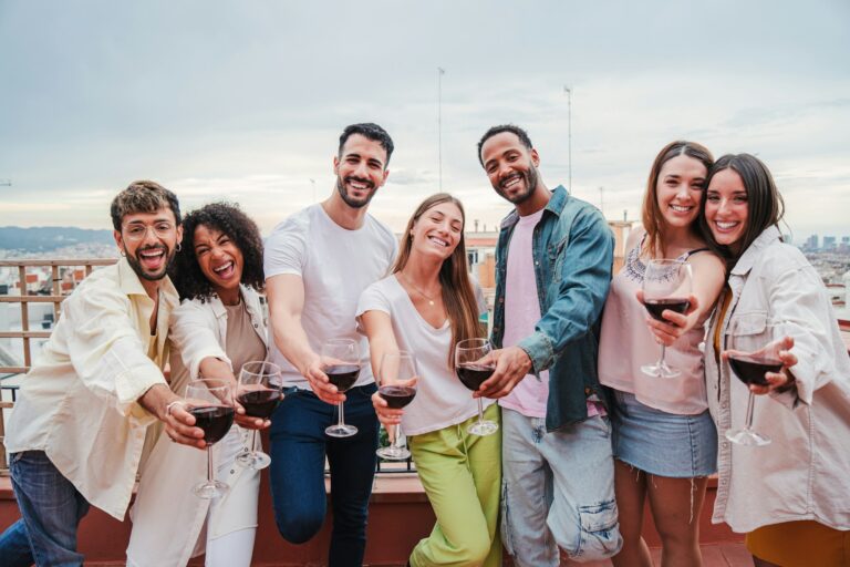 group-of-multicultural-young-adult-friends-having-fun-on-a-rooftop-party-celebration-holding-and