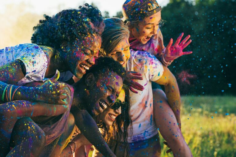 multicultural-happy-friends-piggybacking-together-at-holi-festival