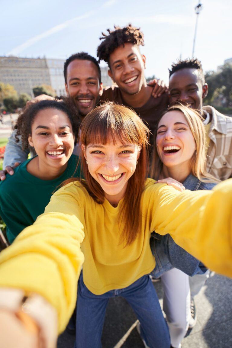 vertical-group-of-happy-friends-posing-for-a-selfie-on-a-spring-day-as-they-party-together-outdoors